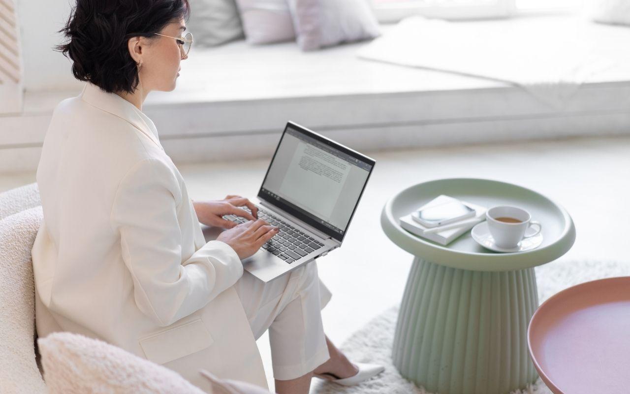 Person typing on a laptop displaying a text document, representing writing a letter of interest to a desired employer.