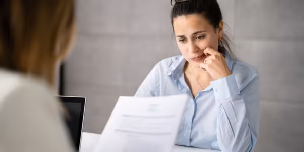 Woman worried as resume is reviewed and mistakes found.