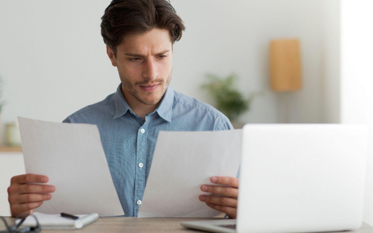 Job Seeker Holding Two Page Resume Trim To One Page